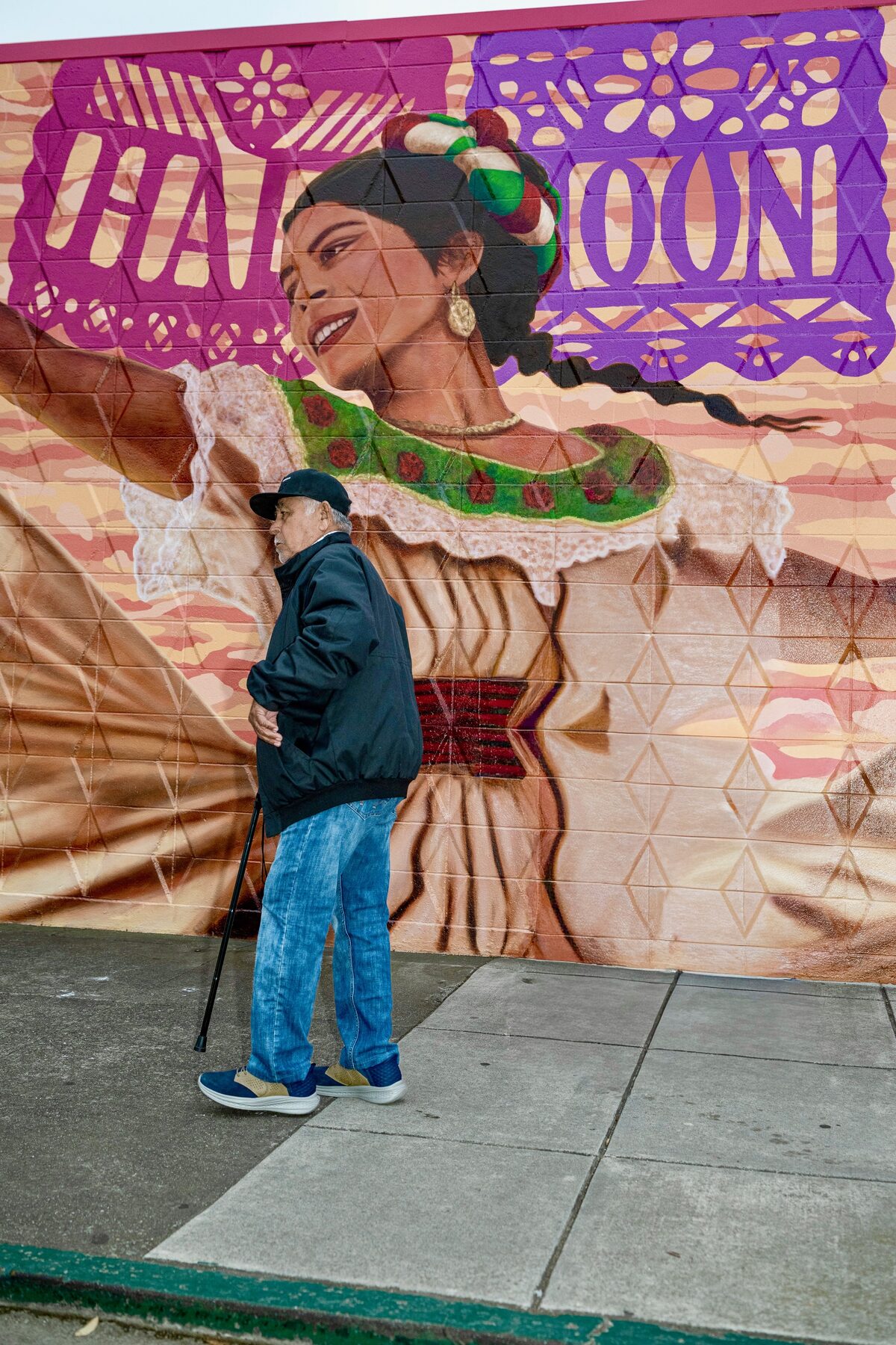 Senior walking past the ALAS community mural in Half Moon Bay